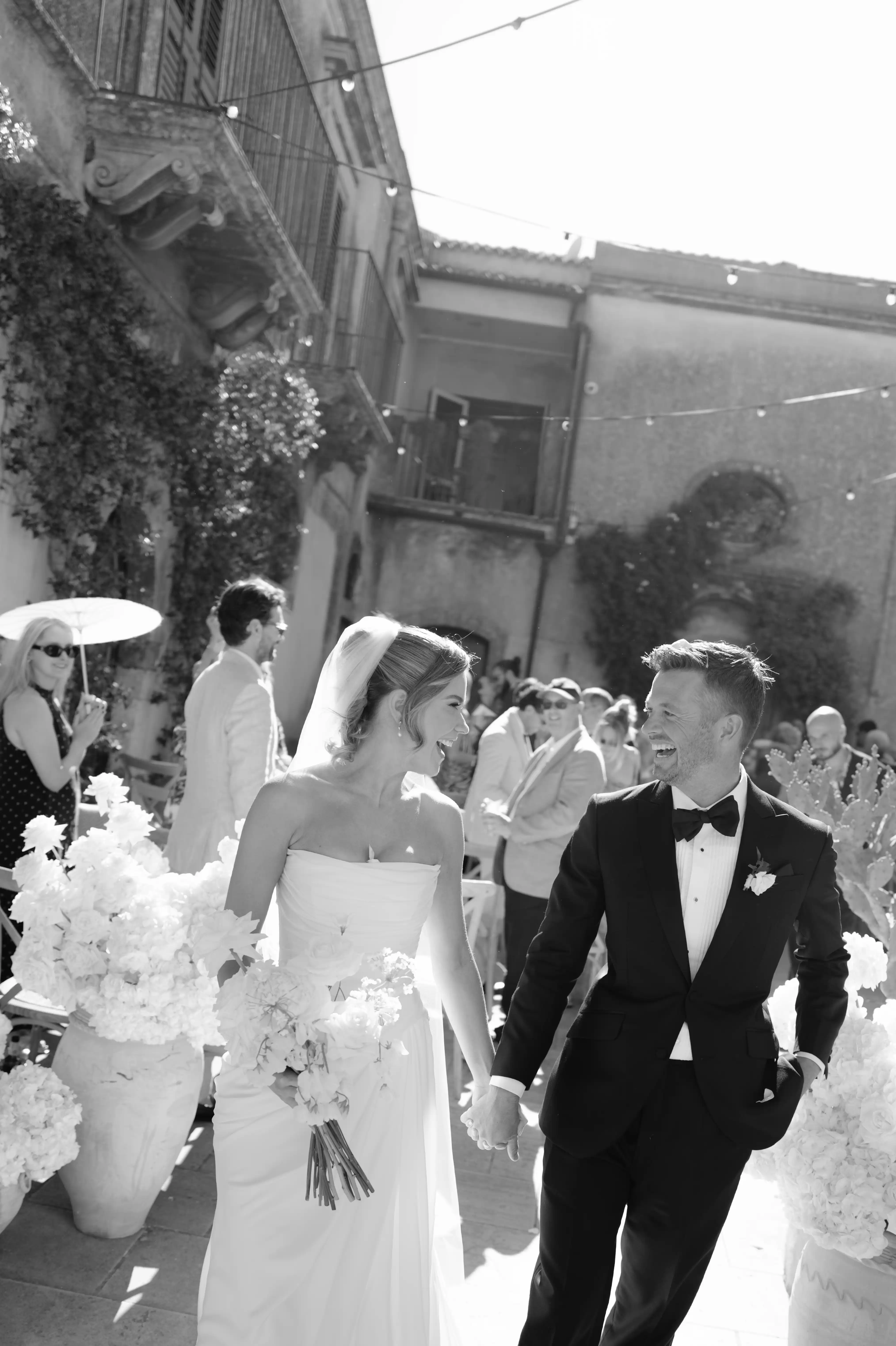 Black and white portrait of bride and groom laughing together after their wedding ceremony in Italy.